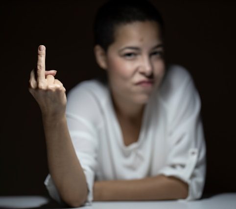 Person holding up middle finger